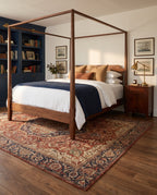 Azar Brick & Navy rug under a walnut four-poster bed in a classic bedroom