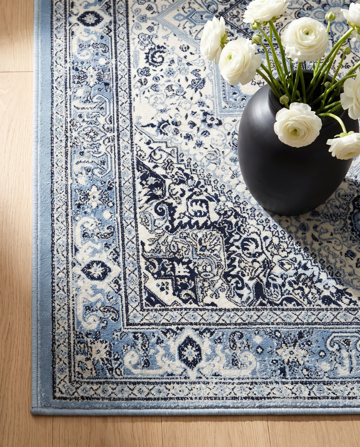 Close-up of the Darya rug sky-blue border and ink motifs, soft low-pile velvet