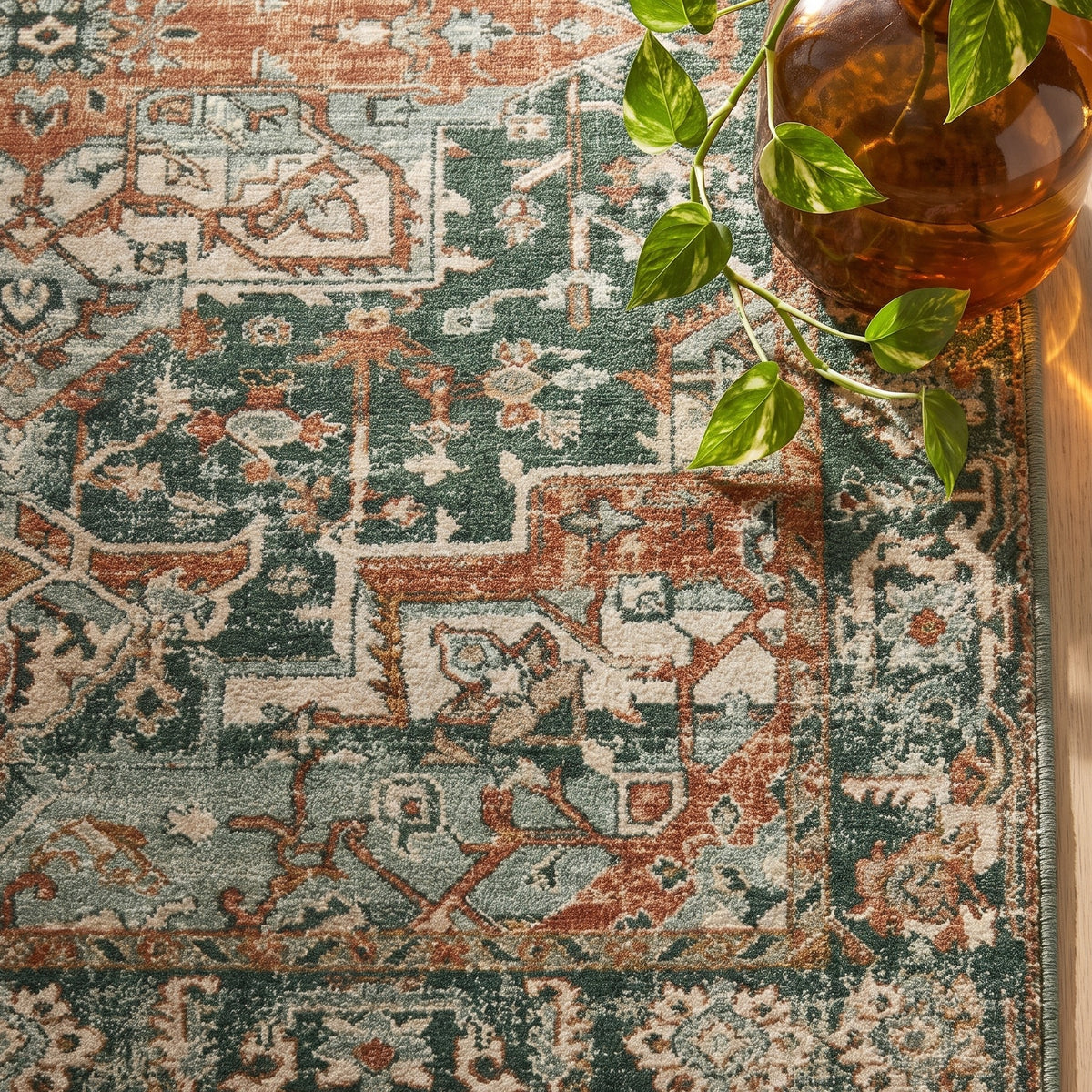 Golbahar rug corner with an amber glass vase and pothos