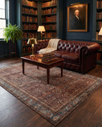 Kahroba Walnut & Teal rug in a dark academia library with an oxblood chesterfield