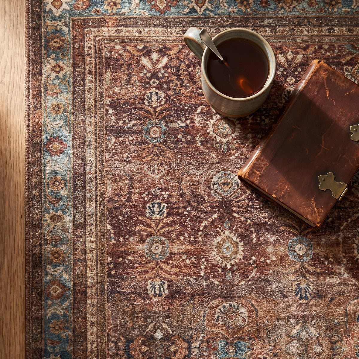 Kahroba rug corner with a mug of tea and a leather-bound book