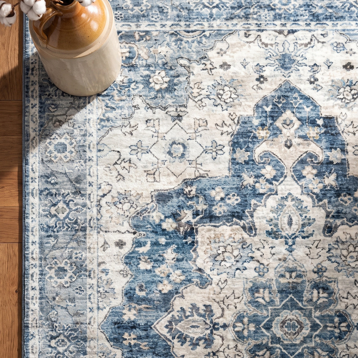 Mahtab rug corner with a stoneware jug of cotton stems
