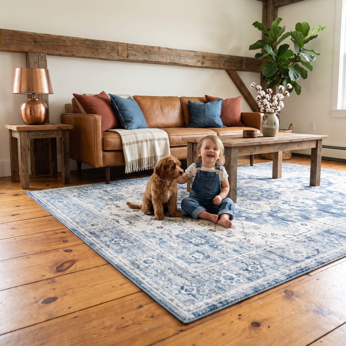 Child in denim overalls and a puppy on the Mahtab Denim & Cream rug