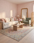 Nasrin Rose & Sage rug in a soft pink living room with a linen sofa and sage armchair