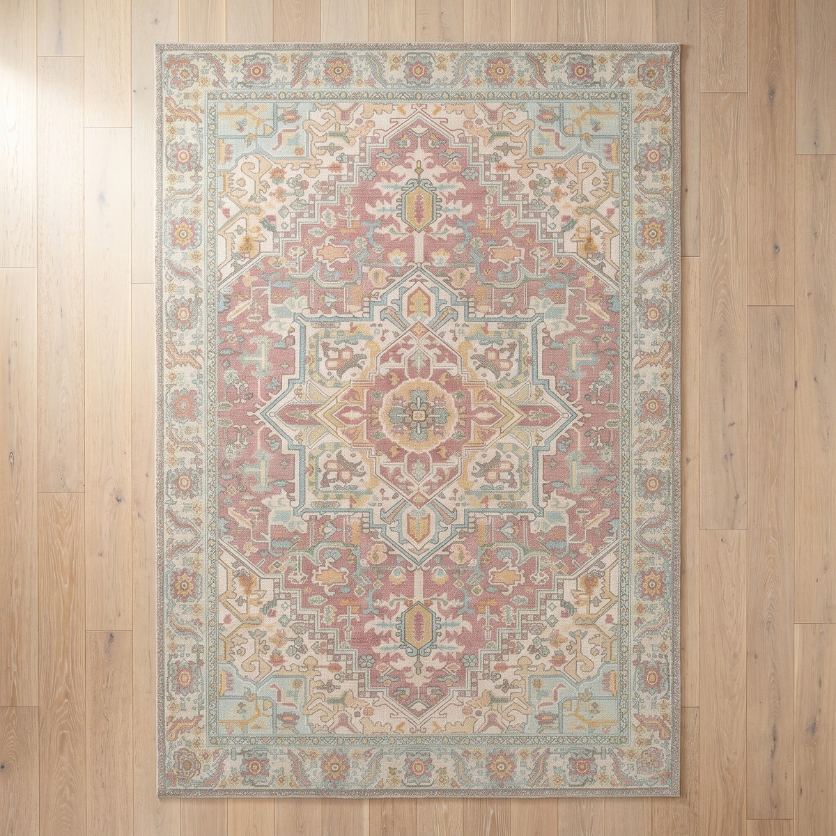 Nasrin Rose & Sage rug seen from above on a pale limed oak floor