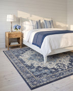 Nilufar Indigo & Ivory rug under a white painted bed in a coastal bedroom