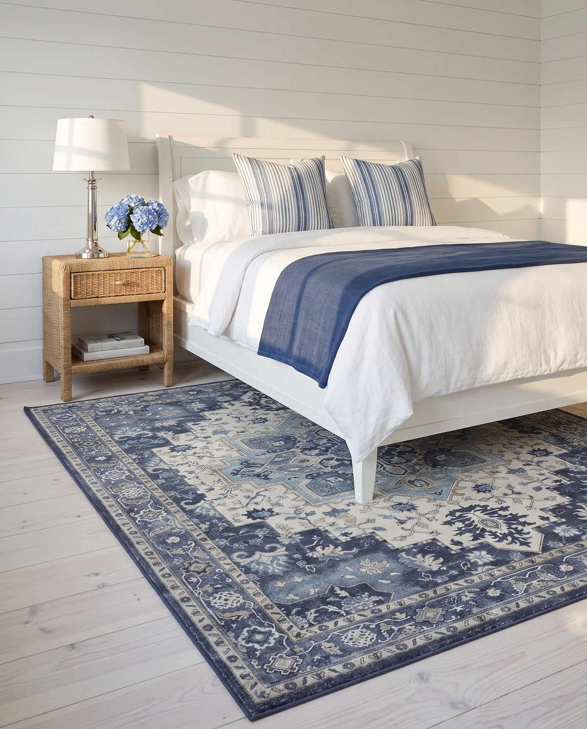 Nilufar Indigo & Ivory rug under a white painted bed in a coastal bedroom