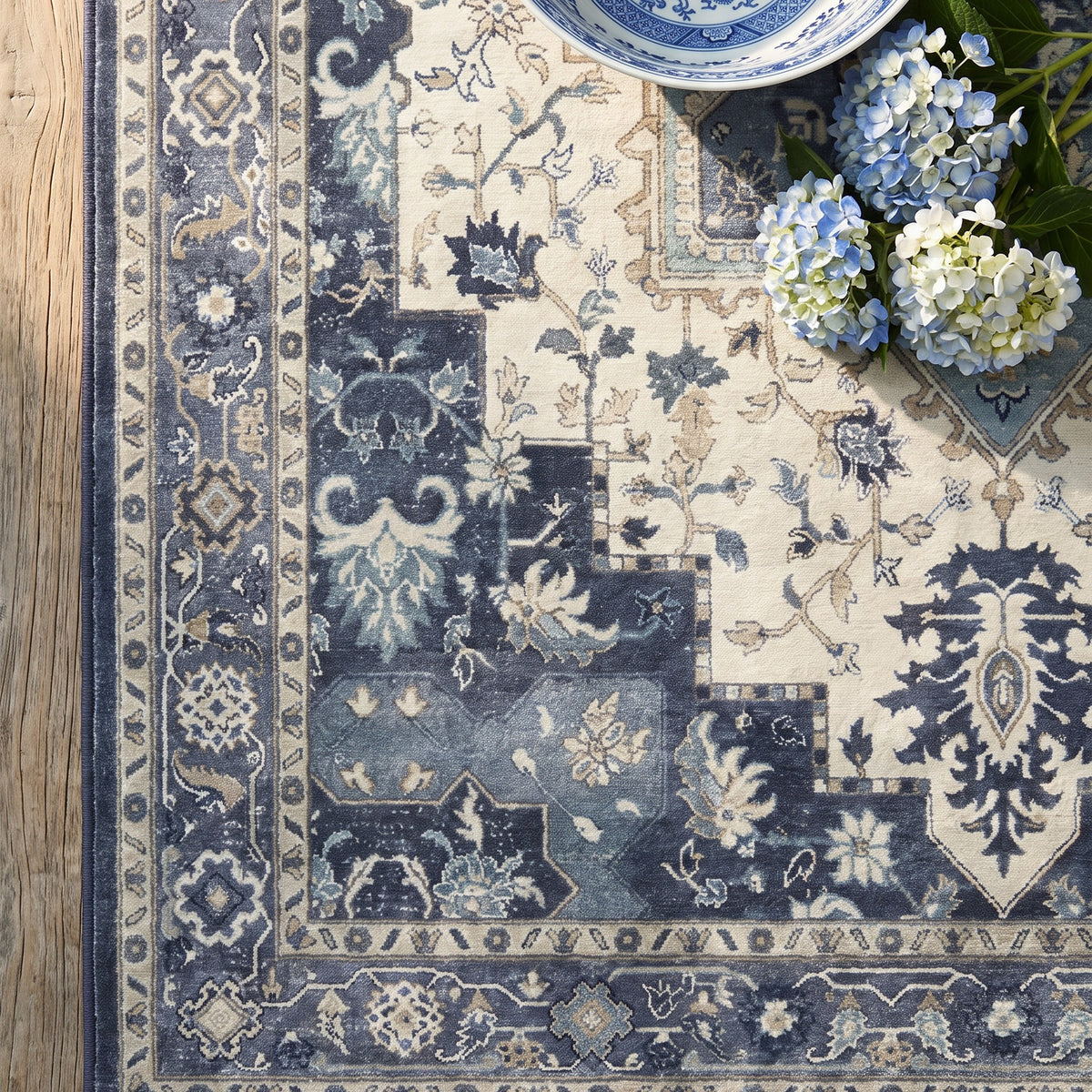 Nilufar rug corner with blue and white porcelain and hydrangeas