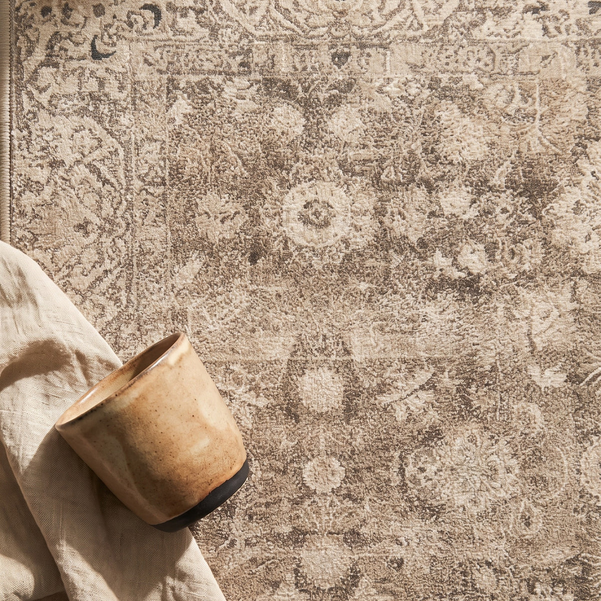 Pardis rug with a handmade clay cup and a linen napkin