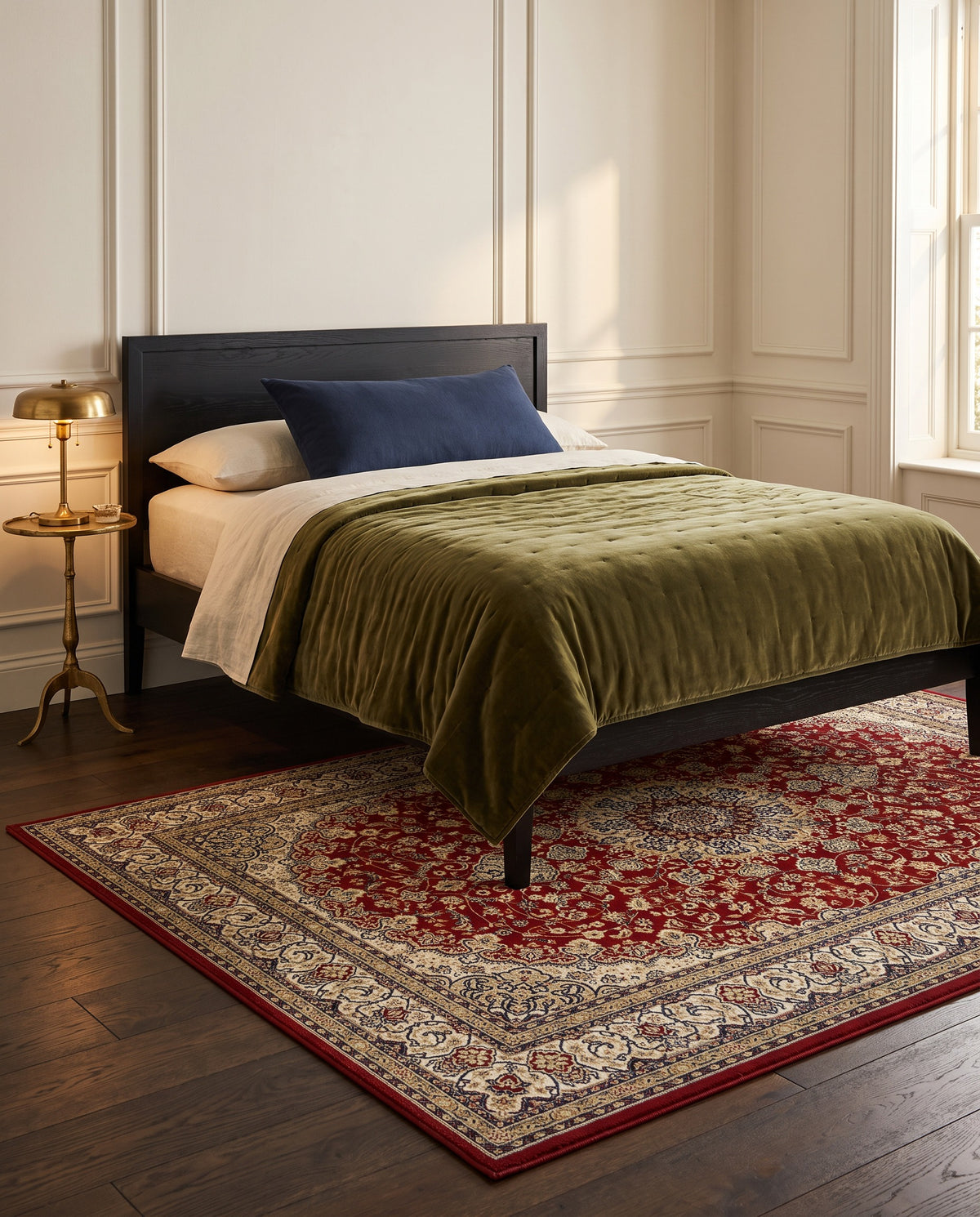 Shahrzad Crimson & Navy rug under an ebonized bed with an olive velvet quilt