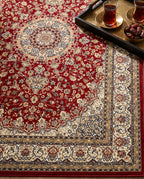 Close-up of the Shahrzad rug crimson field and ivory border, soft low-pile velvet