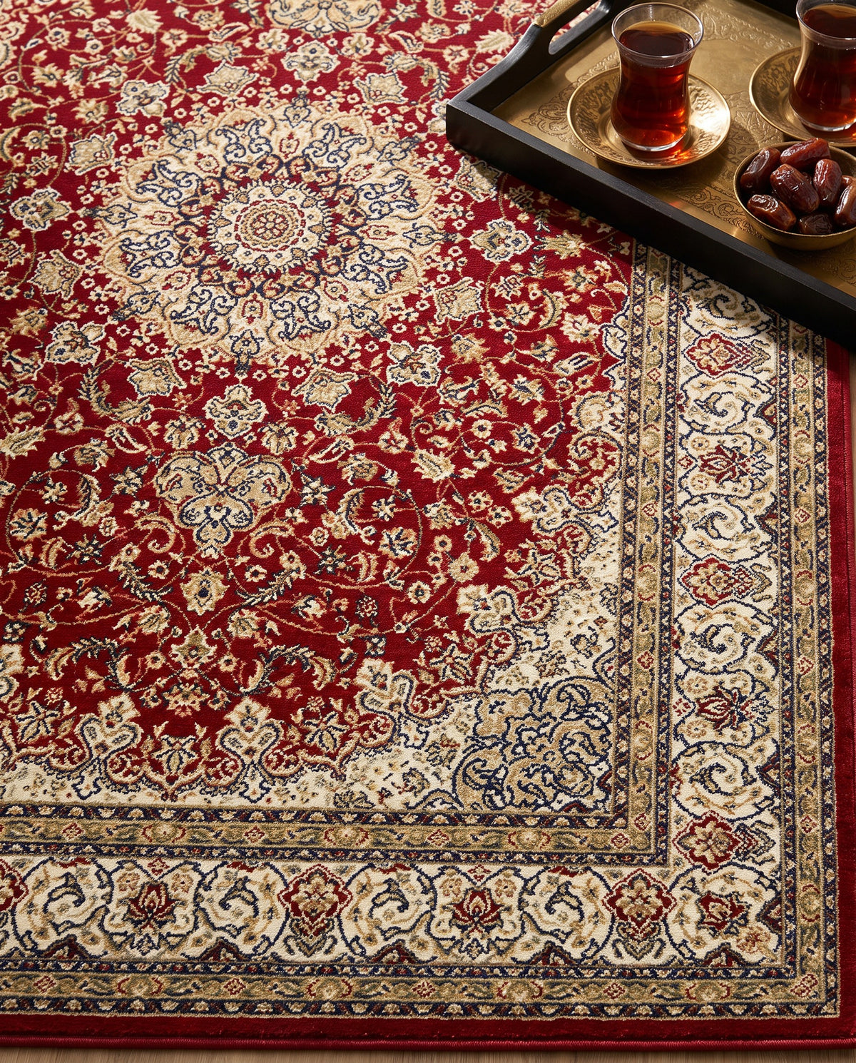 Close-up of the Shahrzad rug crimson field and ivory border, soft low-pile velvet
