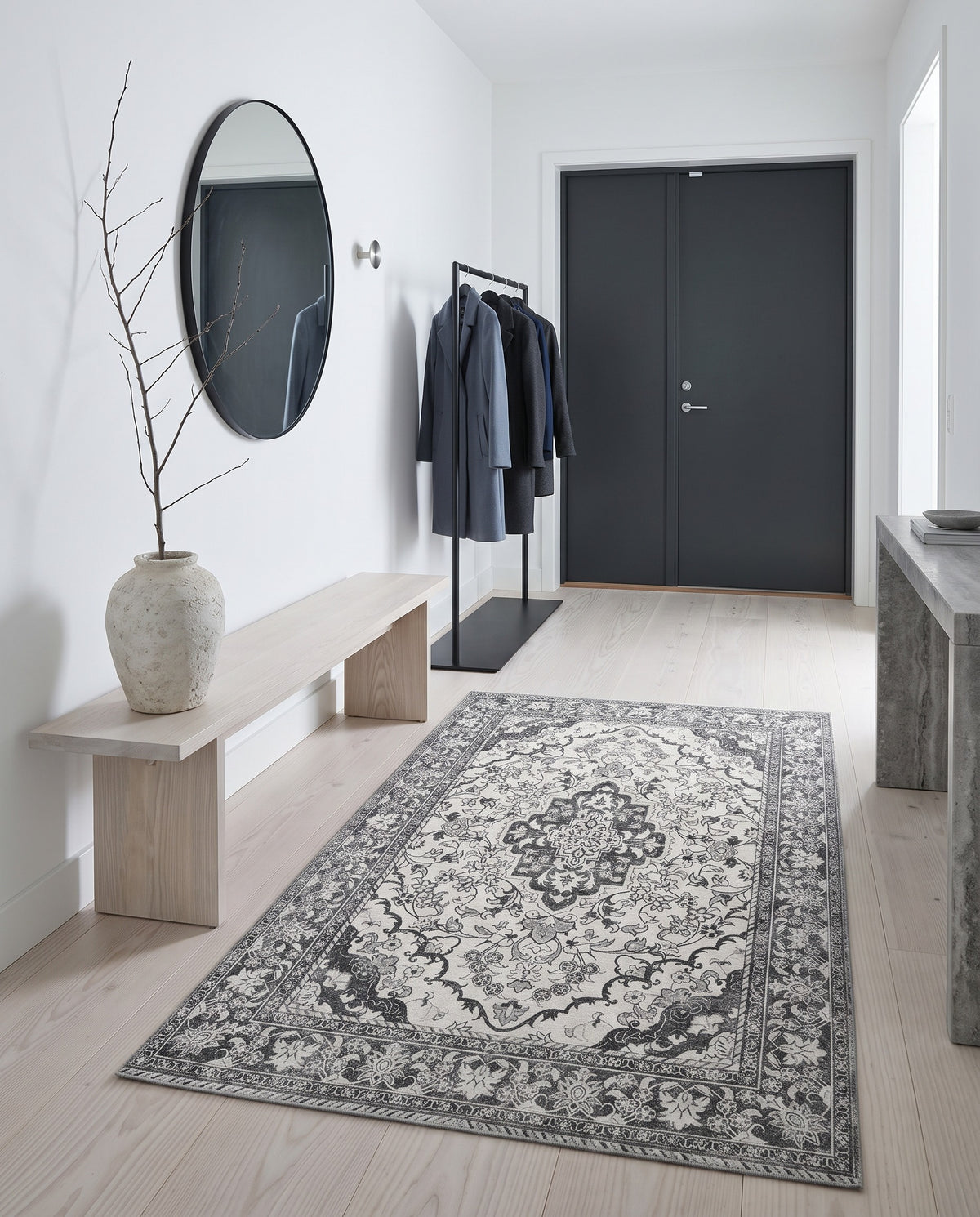 Simin Ash & Ivory rug in a bright minimalist entryway with a pale ash bench