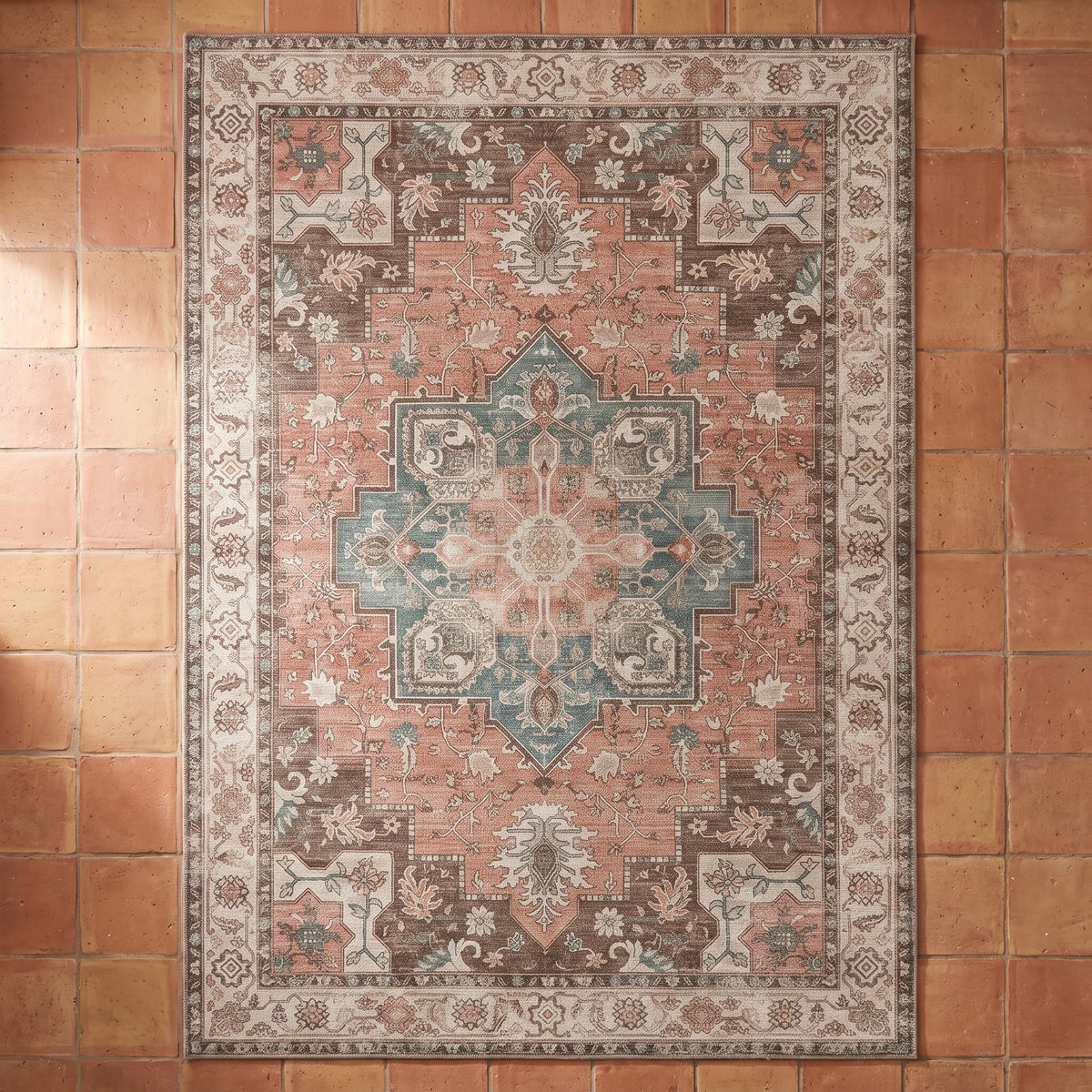 Soraya Terracotta & Teal rug seen from above on a terracotta tile floor