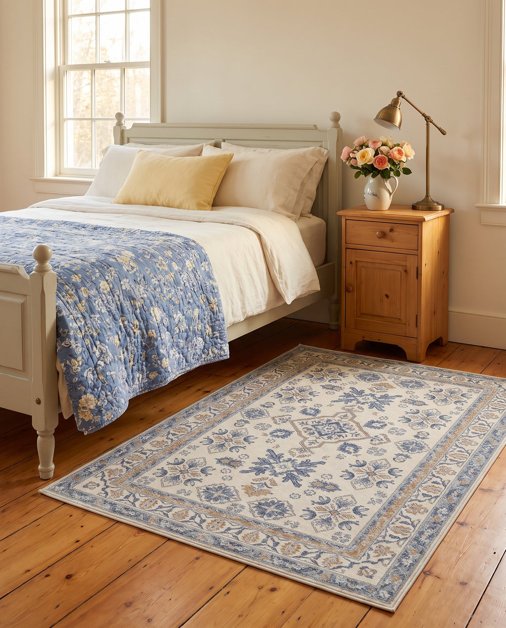 Yasaman Ivory & Cornflower rug beside a painted wooden bed with a cornflower quilt