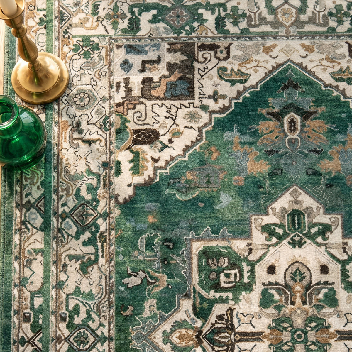 Zomorrod rug with a brass candlestick and an emerald glass vase